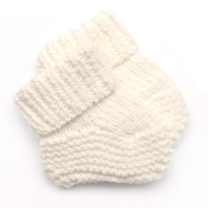 May include: A pair of white knitted baby booties with a folded cuff.