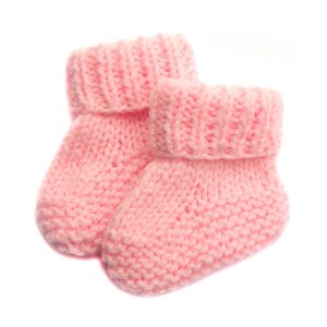 May include: A pair of pink knitted baby booties. The booties are made of a soft, fluffy yarn and have a simple, classic design.