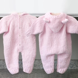Puede incluir: Dos peleles rosas de punto para beb&eacute;. Uno est&aacute; abotonado y el otro tiene una capucha con peque&ntilde;os detalles en forma de orejas. Ambos tienen mangas largas y textura acanalada. Los peleles est&aacute;n dise&ntilde;ados para beb&eacute;s.