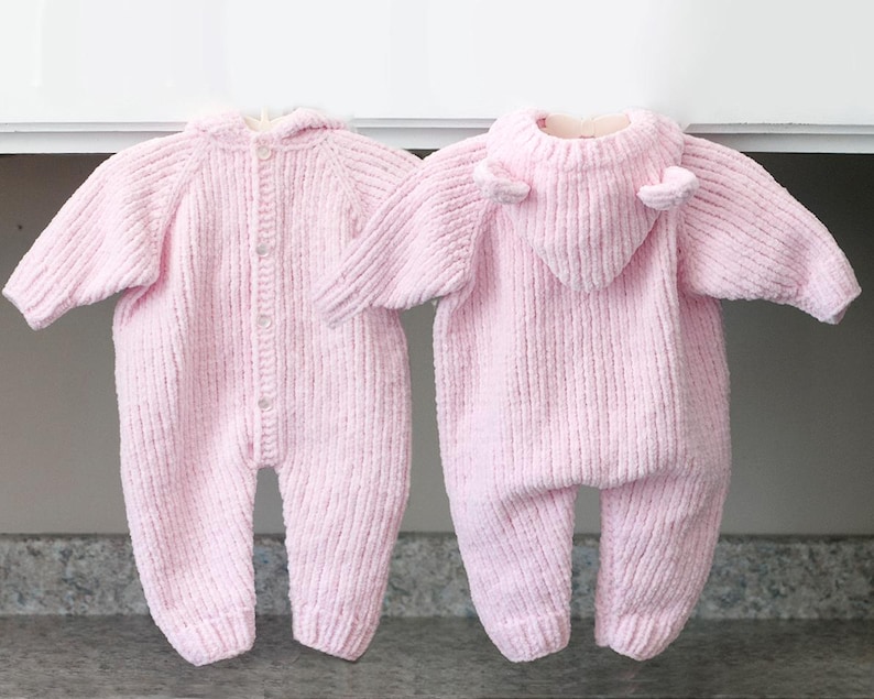 Puede incluir: Dos peleles rosas de punto para beb&eacute;. Uno est&aacute; abotonado y el otro tiene una capucha con peque&ntilde;os detalles en forma de orejas. Ambos tienen mangas largas y textura acanalada. Los peleles est&aacute;n dise&ntilde;ados para beb&eacute;s.