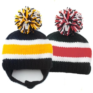 May include: Two knitted winter hats with pom poms. One hat is black with a white and yellow stripe, the other is black with a white and red stripe.