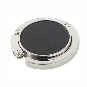 May include: A silver-toned metal purse hook with a black leather pad. The hook folds for easy storage.