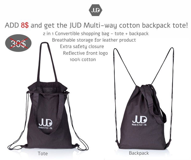 May include: A black cotton tote bag with drawstring closure and adjustable straps. The bag can be worn as a backpack or carried as a tote. The bag has a white logo that says "JUD Made in TLV - ISL".