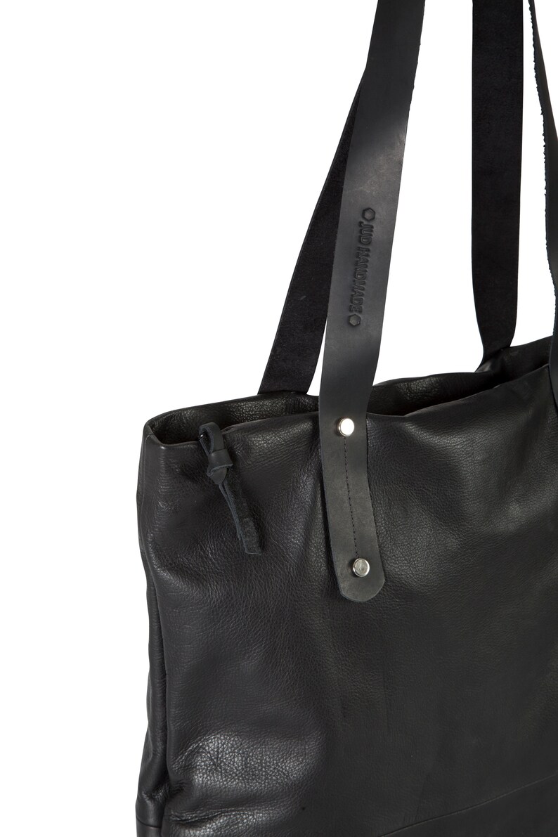 May include: Black leather tote bag with two long straps. The straps have the text "OLD MADE" embossed on them.