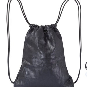 May include: A black leather drawstring backpack with a snakeskin pattern. The backpack has a small logo on the front.