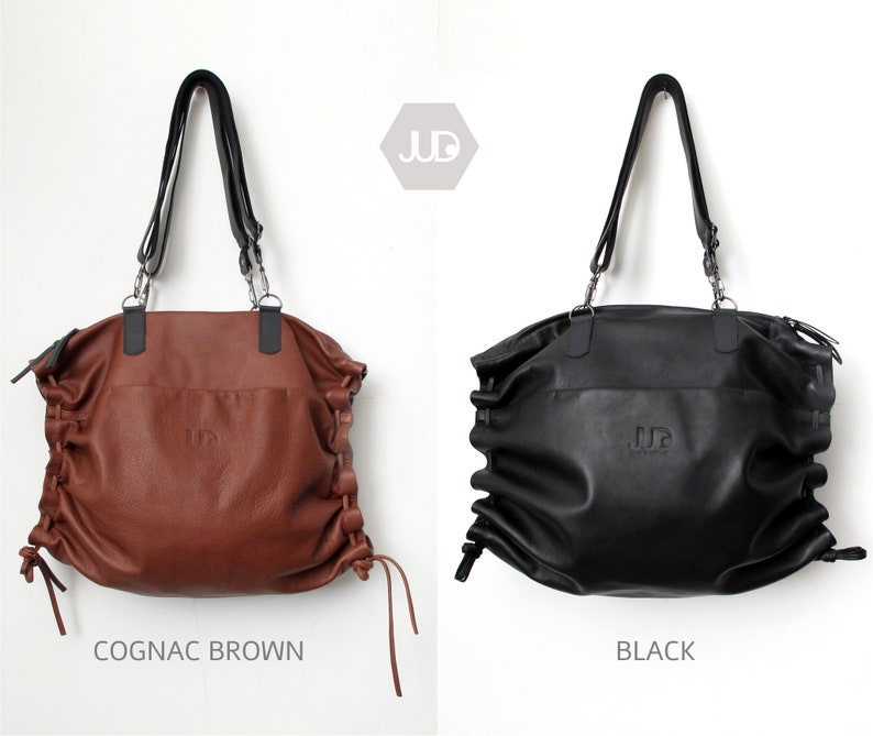 May include: Two leather tote bags with adjustable straps. The bag on the left is cognac brown and the bag on the right is black. Both bags have the word "JUD" embossed on the front.