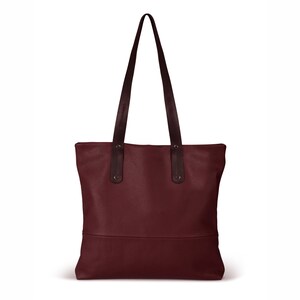 May include: A burgundy leather tote bag with black leather handles. The bag has a simple design and a spacious interior.