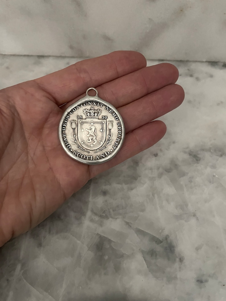 May include: Silver coin with a lion and a crown on the front. The coin reads "DEUS  CONJUNXIT  NEMO  SEPARARE  POTEST" and "SCOTLAND".