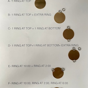 May include: Diagram showing different ring placement options for a round metal charm. The options include one ring at the top, one ring at the top with an extra ring, one ring at the top and one at the bottom, one ring at the top and one at the bottom with an extra ring, one ring at 10:00 and one at 2:00, and one ring at 10:00, one at 2:00, and one at 6:00.