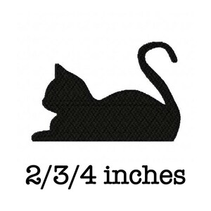 May include: Black embroidered cat silhouette, lying down with curled tail. The text "2/3/4 inches" is below the cat, indicating the size of the design. The cat is approximately 2.75 inches in length.
