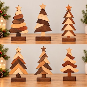 May include: Six decorative wooden Christmas tree ornaments, each featuring a star topper and a rectangular base. The trees are crafted from various shades of light and dark wood, showcasing different geometric patterns and layered designs.
