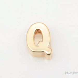 May include: Gold letter charm in the shape of the letter Q.