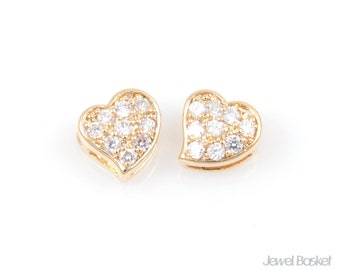 May include: A pair of gold heart-shaped earrings with clear cubic zirconia stones.
