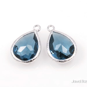 Könnte beinhalten: Ein Paar silberne Ohrringe in Tropfenform mit blauen Kristall-Akzenten.