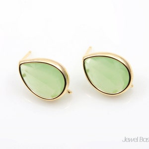 May include: A pair of gold earrings with light green teardrop-shaped stones.