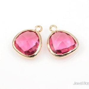 Pode incluir: Dois pingentes de vidro rosa em forma de lágrima com engastes de metal dourado. Os pingentes têm um design facetado e são perfeitos para a criação de joias.