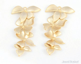 May include: A pair of gold-tone earrings with a cascading flower design. Each earring features four flower-shaped charms, with the top charm being the largest and the bottom charm being the smallest.
