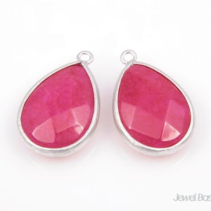 May include: A pair of silver teardrop-shaped earrings with pink gemstone accents.