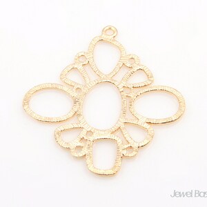 Peut inclure: Pendentif en métal doré avec un design délicat et complexe composé de plusieurs cercles et ovales qui se chevauchent. Le pendentif a une boucle en haut pour l'attacher à une chaîne ou un cordon.