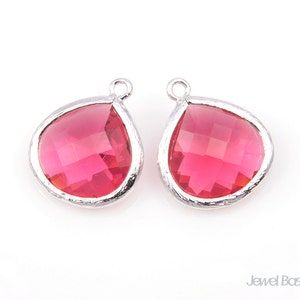 May include: Two silver teardrop-shaped pendants with pink crystal accents.