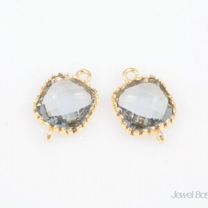 May include: Two gold-toned metal charms with clear faceted glass stones. Each charm has a loop for attaching to jewelry.