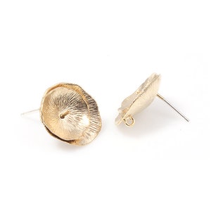 May include: A pair of gold-tone flower-shaped earring posts. The earrings are made of metal and have a textured surface.