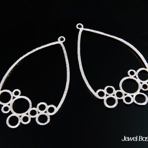 Peut inclure: Deux ébauches de boucles d'oreilles en argent en forme de larme avec un motif de bulles. Les ébauches sont en métal et ont une finition texturée.