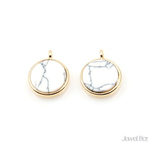 May include: Two gold-toned round pendants with white marble inlays. The pendants have a smooth, polished finish and are perfect for adding a touch of elegance to any jewelry project.