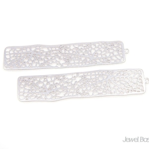 Puede incluir: Dos formas rectangulares de filigrana de metal plateado con un diseño delicado e intrincado. Las formas son de tamaño similar y tienen un borde ligeramente redondeado.