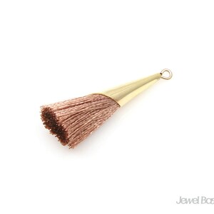May include: A light brown tassel with a gold metal loop at the top.