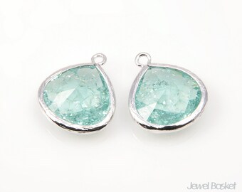 Könnte beinhalten: Ein Paar silberne Anhänger in Tropfenform mit hellblauen facettierten Glassteinen.