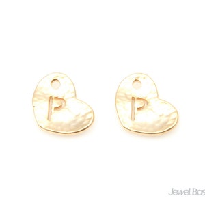 May include: Two gold heart-shaped charms with a hammered texture. Each charm has a letter "P" cut out of the centre.