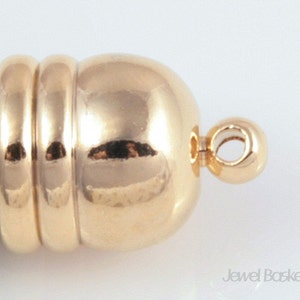 May include: Gold-toned metal clasp with a round, smooth ball and a loop for attaching to a necklace or bracelet.