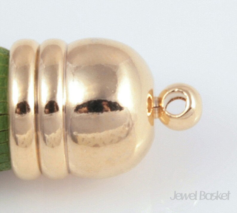 May include: Gold-toned metal clasp with a round, smooth ball and a loop for attaching to a necklace or bracelet.