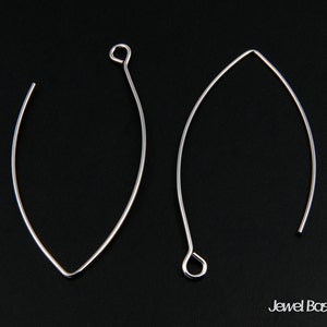 May include: Two silver earring hoops, one is a simple oval shape and the other is a more rounded oval shape with a small loop at the top.