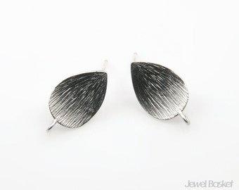 May include: A pair of silver earrings shaped like teardrops with a textured surface.