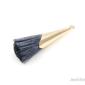 May include: A gray tassel with a gold metal cone-shaped top. The tassel is made of soft, fine fibers and is perfect for adding a touch of elegance to any project.