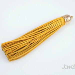 May include: A yellow leather tassel with a gold metal top. The tassel is about 6 inches long.