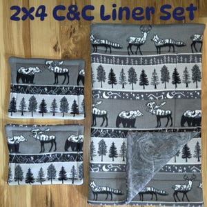 May include: A 2x4 C&C Liner Set consisting of one large rectangular fleece liner and two smaller rectangular fleece liners. All pieces feature a gray background with a repeating black and white pattern of bears, deer, and pine trees.