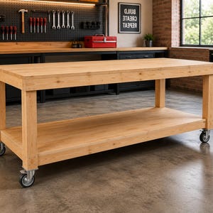 May include: A rectangular light-colored wooden workbench featuring a smooth top surface and a lower storage shelf. The structure is supported by four sturdy legs, each equipped with a swivel caster wheel for mobility.