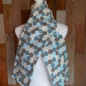 May include: A soft, cozy fleece scarf with a pattern of blue and gray circles. The scarf is folded and draped over a white mannequin.
