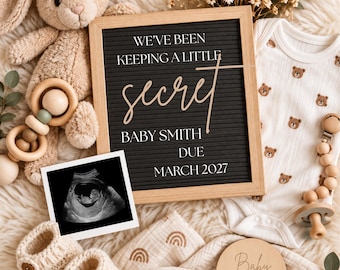 Può includere: Una lavagna a lettere nera con il testo WE'VE BEEN KEEPING A LITTLE secret BABY SMITH DUE MARCH 2027, accompagnata da un body con stampa di orsetti, un coniglio di peluche, un'ecografia, scarpine in maglia e un disco in legno.