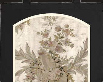 Può includere: Una borsa tote nera con un pannello grafico centrale ad arco. Il pannello presenta uno sfondo beige chiaro con un'illustrazione dettagliata di composizioni floreali nei toni del rosa e del verde spento, tra cui rose e fogliame, attorno a un tamburello.
