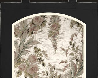 Può includere: Una borsa tote nera con un pannello centrale ad arco su sfondo color crema. Il pannello presenta un motivo floreale dettagliato con rose rosa tenue, foglie verde spento ed elementi botanici ricadenti in stile vintage.
