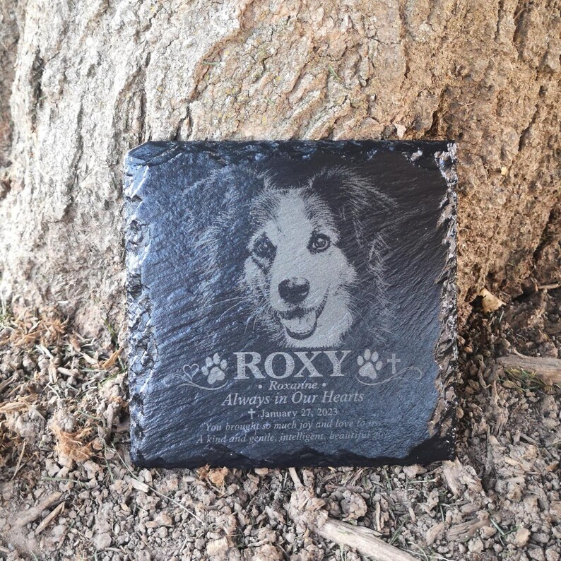Może przedstawiać: Kwadratowa tablica pamiątkowa z czarnego łupka z wygrawerowanym portretem psa. Tekst zawiera napisy ROXY, Roxanne, Always in Our Hearts, January 27, 2023 oraz You brought so much joy and love to us. A kind and gentle, intelligent, beautiful girl.