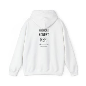 May include: A white hooded sweatshirt featuring the black text ONE MORE HONEST REP. printed on the back, accompanied by a small barbell graphic and the smaller text RAW'S FAITH & FITNESS positioned directly below the barbell icon.