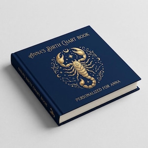 Pode incluir: Um livro de capa dura azul-escuro intitulado Anna's Birth Chart Book. A capa apresenta uma ilustração dourada de um escorpião rodeado por símbolos celestiais e estrelas. O texto Personalized for Anna está impresso em dourado.