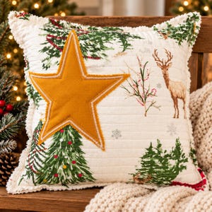 May include: A square quilted throw pillow featuring a cream-colored fabric with a printed pattern of green pine trees, a brown deer, and small snowflakes. A large, solid mustard-yellow fabric star is appliqued onto the front surface.