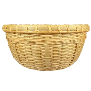 May include: A woven, light brown, round basket with a wide, flat base and a slightly curved rim.