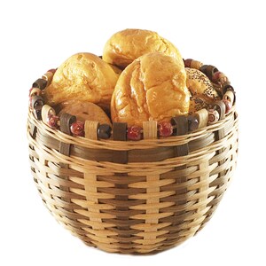 May include: A woven wicker basket with a brown and tan pattern, filled with four round bread rolls. The basket has a decorative trim of red and brown beads.